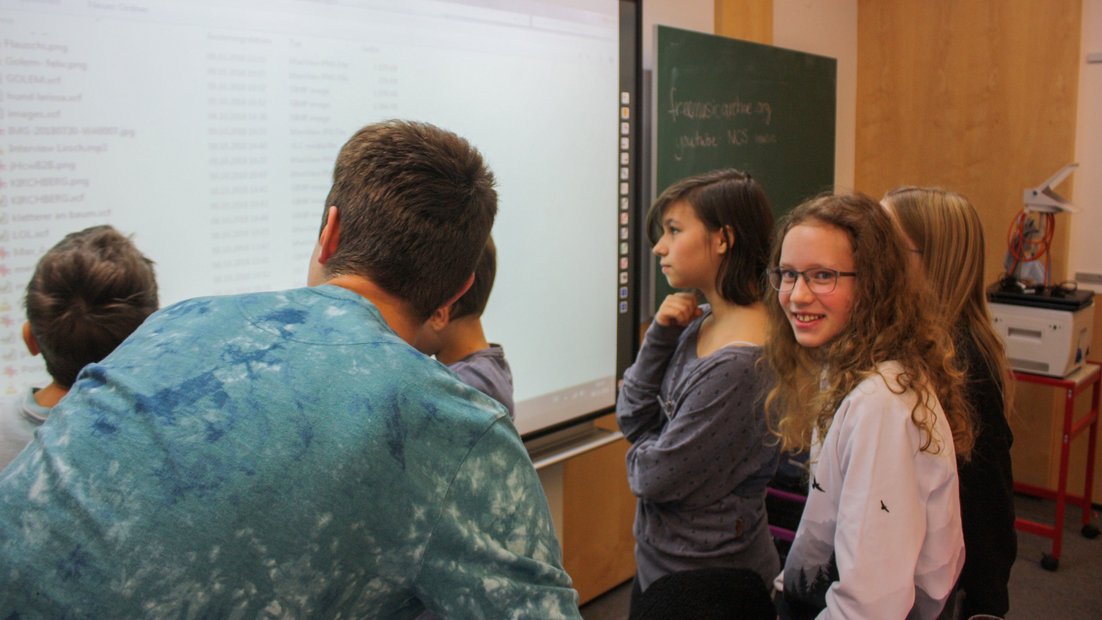 Pupils view beamer projection on whiteboard.