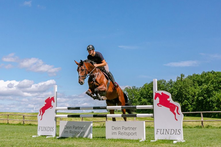 Martin Fundis auf seinem Pferd beim Überwinden eines Steilsprungs auf der Reitkoppel