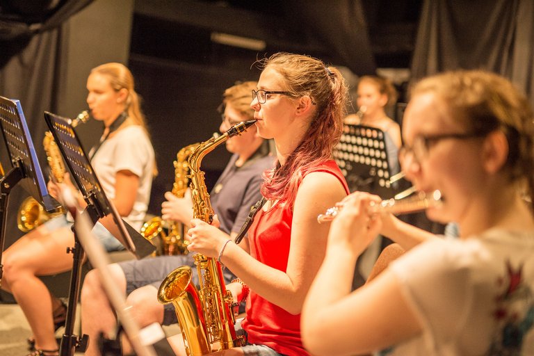 Schüler spielen verschiedene Instrumente in einer Band.